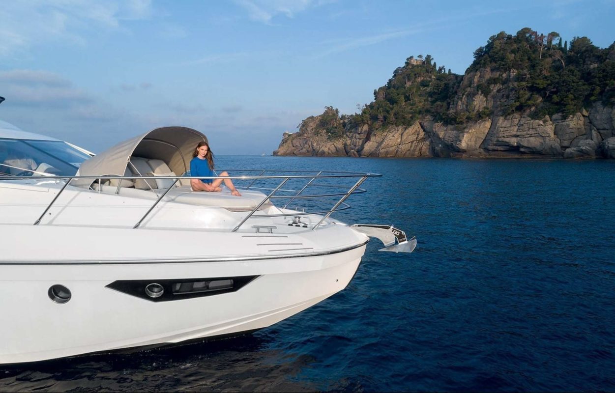 Side view of a white yacht with a woman on board