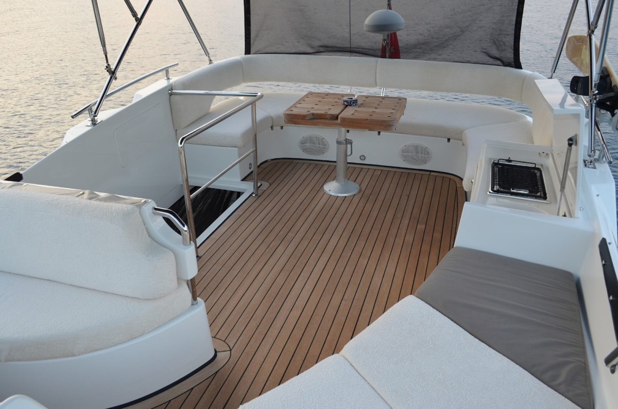 Image of the stern of a boat featuring tables and sofas