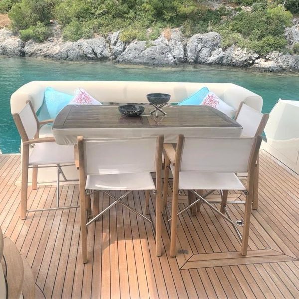 Image of the stern of a boat featuring tables and sofas