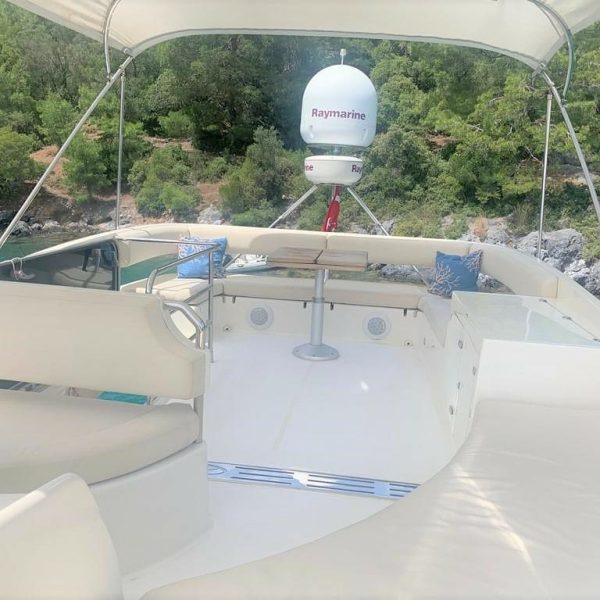 Image of the stern of a boat featuring tables and sofas