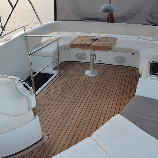 Image of the stern of a boat featuring tables and sofas